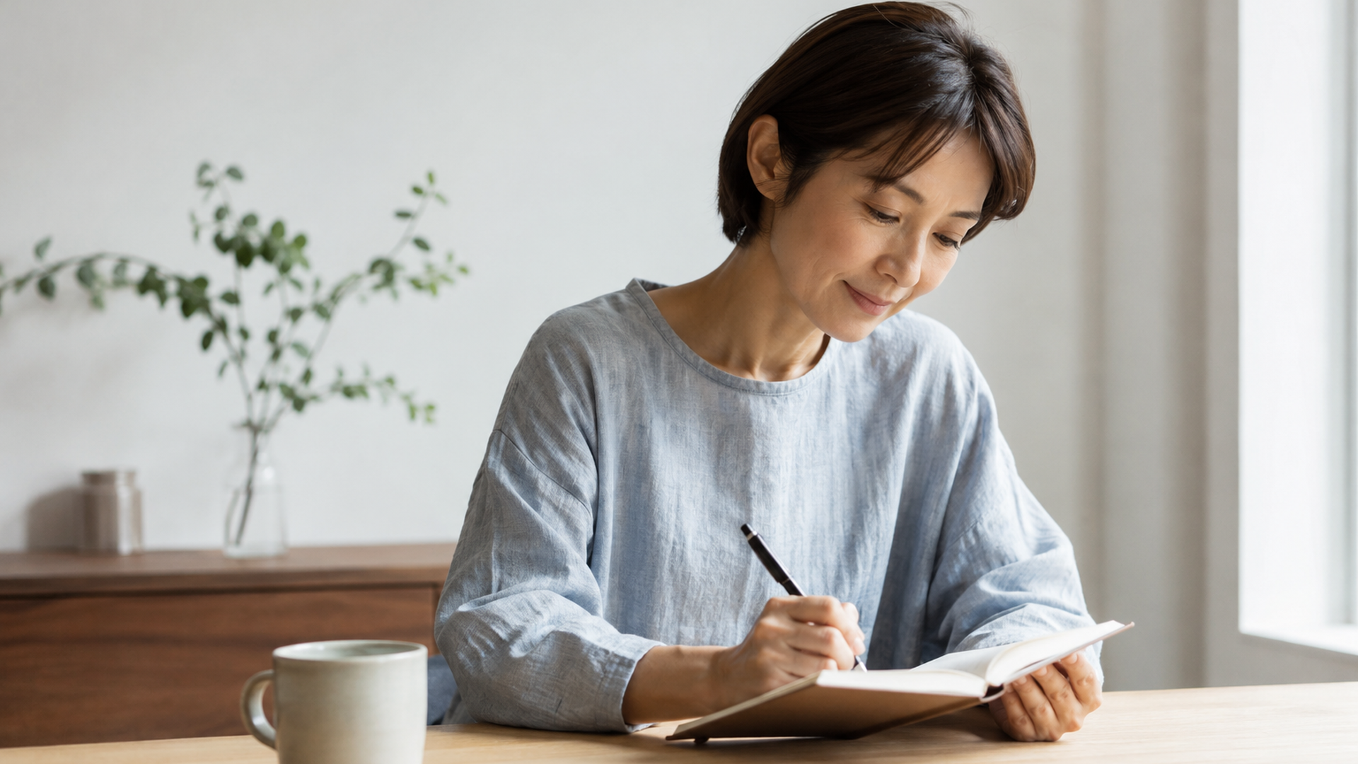 手帳に寝つきや朝の休養感と疲れの変化を記録する大人